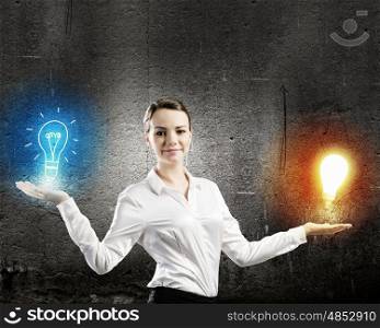 Businesswoman with items. Image of young businesswoman holding bulb on palm