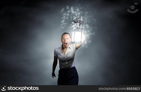 Businesswoman with lantern. Young businesswoman walking in darkness with lantern in hand