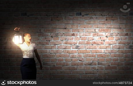 Businesswoman with lantern. Young businesswoman walking in darkness with lantern in hand