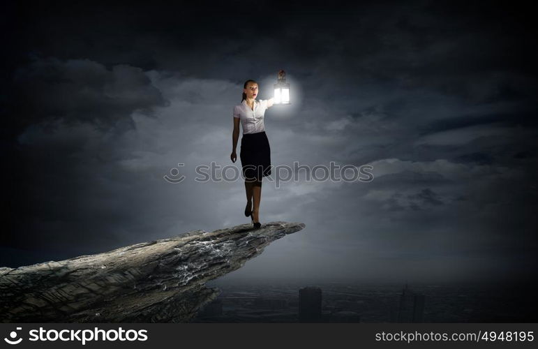 Businesswoman with lantern. Young businesswoman walking in darkness with lantern in hand