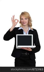 Businesswoman with laptop giving the OK signal