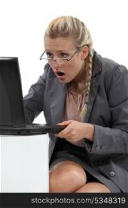 Businesswoman with laptop looking surprised