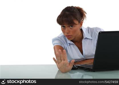 Businesswoman with laptop making stop gesture