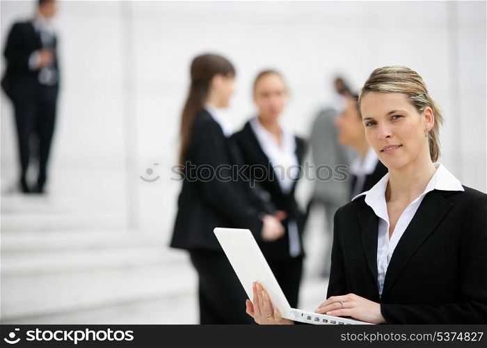 Businesswoman with laptop outdoors