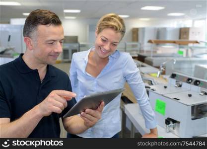 businesswoman with male colleague using digital tablet in office