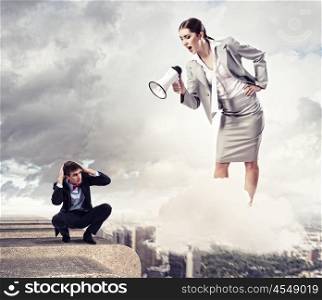 Businesswoman with megaphone. Angry businesswoman with megaphone shouting at colleague