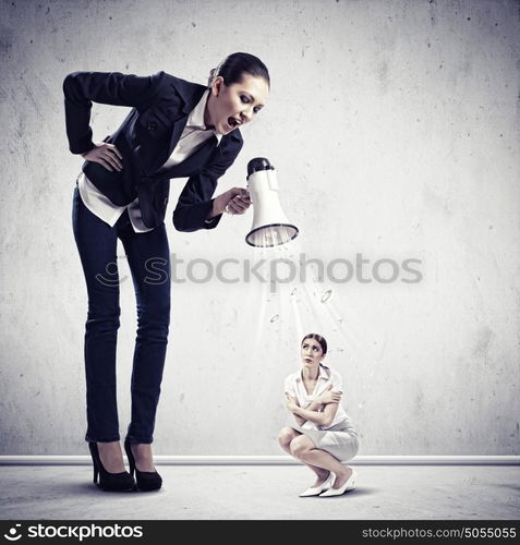 Businesswoman with megaphone. Angry businesswoman with megaphone shouting at colleague