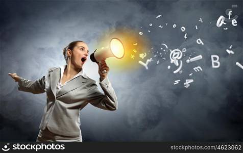 businesswoman with megaphone. businesswoman in grey suit screaming into megaphone