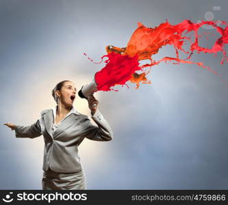 businesswoman with megaphone. businesswoman in grey suit screaming into megaphone