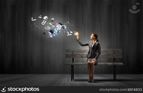 Businesswoman with mobile phone. Young businesswoman holding mobile phone with flying out icons