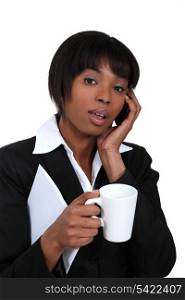 Businesswoman with mug of coffee and telephone