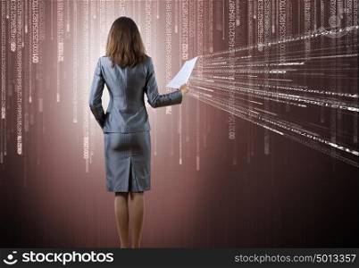 Businesswoman with papers. Rear view of businesswoman against binary background