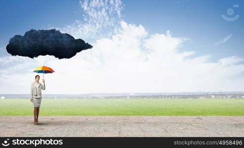 Businesswoman with umbrella. Young businesswoman with colorful umbrella under black cloud