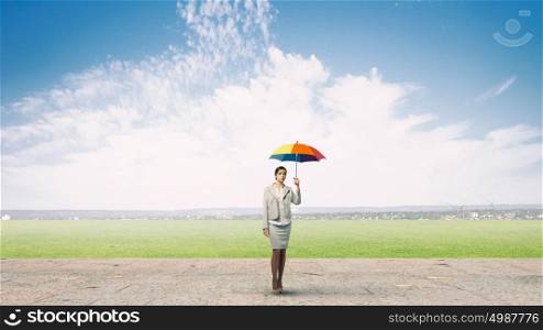 Businesswoman with umbrella. Young pretty businesswoman in suit with colorful umbrella