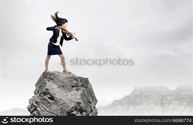 Businesswoman with violin. Young determined woman in black suit playing violin