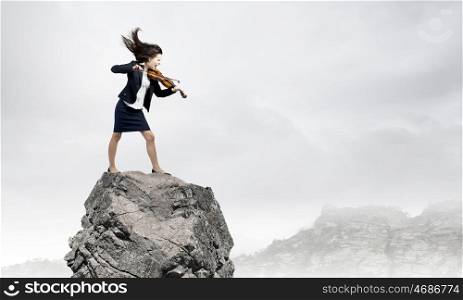Businesswoman with violin. Young determined woman in black suit playing violin