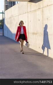 Businesswoman woman wearing red jacket walking on the street