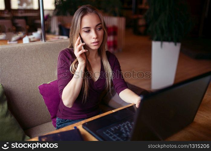 Businesswoman work in cafe using internet technology. Young woman with phone and laptop. Business people lifestyle.. Business people lifestyle