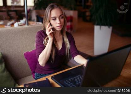 Businesswoman work in cafe using internet technology. Young woman with phone and laptop. Business people lifestyle.. Business people lifestyle