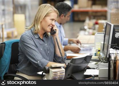 Businesswoman Working At Desk In Warehouse