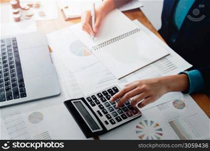 businesswoman working in office with using a calculator to calculate the numbers finance accounting concept
