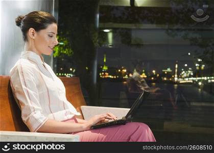 Businesswoman working on a laptop at an airport lounge