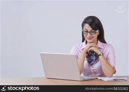 Businesswoman working on laptop at office desk