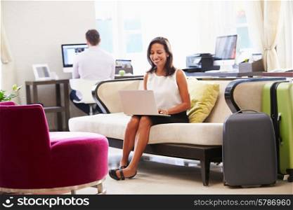 Businesswoman Working On Laptop In Hotel Lobby