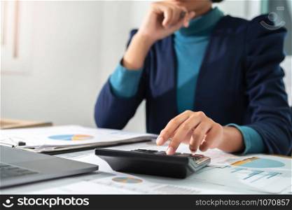 businesswoman working using calculator and laptop in office. concept finance and accounting