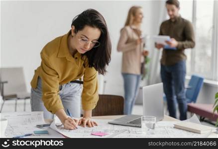 businesswoman working while her teammates are talking