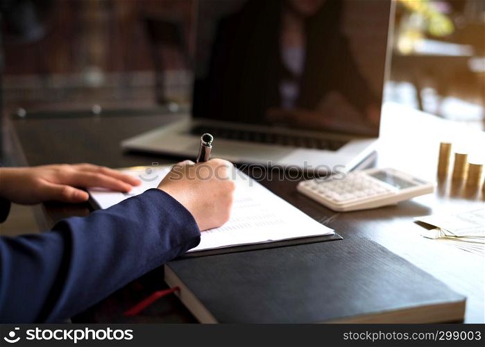 Businesswoman working with income statement document on the wood table.Business concept.