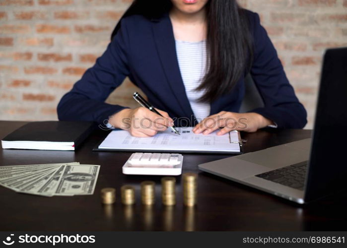 Businesswoman working with income statement document on the wood table.Business concept.