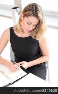 Businesswoman writing appointment on agenda