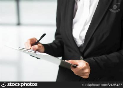businesswoman writing clipboard with black pen