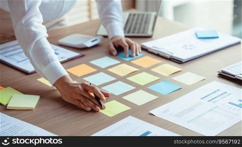 Businesswoman writing data in sticky notes on table to sharing ideas about strategy of new business.