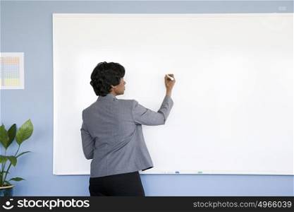 Businesswoman writing on whiteboard