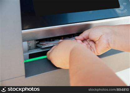 Businesswoman wtihdrawing money from bank atm for transaction. Bank ATM transaction