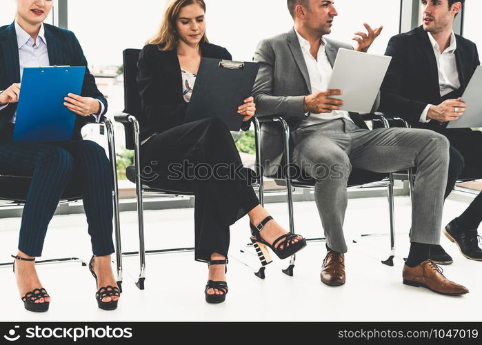 Businesswomen and businessmen holding resume CV folder while waiting on chairs in office for job interview. Corporate business and human resources concept.