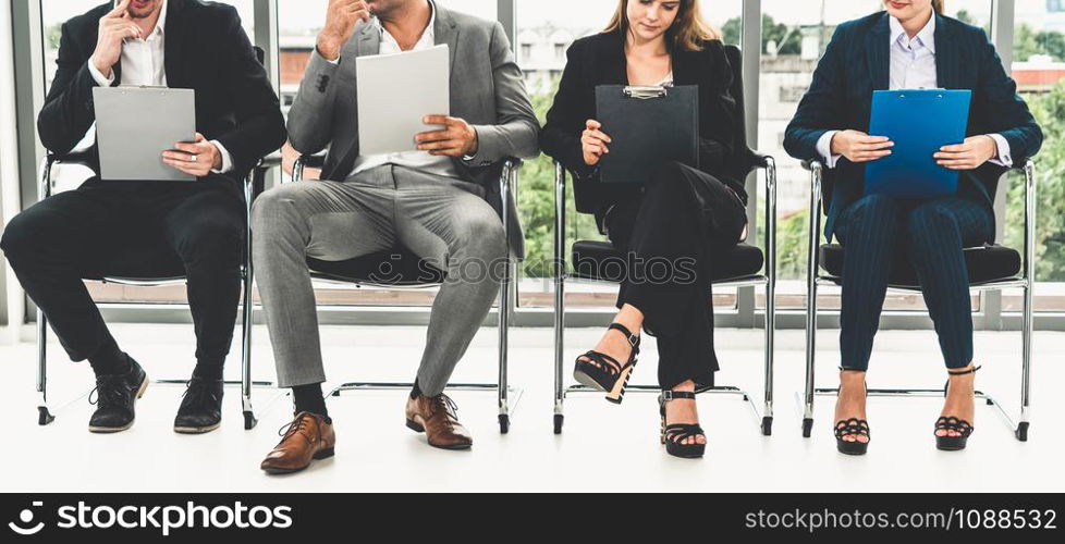 Businesswomen and businessmen holding resume CV folder while waiting on chairs in office for job interview. Corporate business and human resources concept.