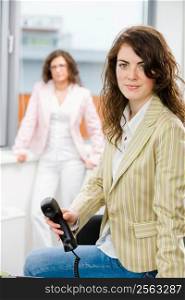 Businesswomen at office, business woman calling on phone.