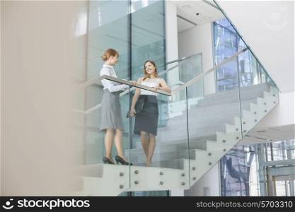 Businesswomen conversing on steps in office
