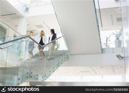 Businesswomen conversing while moving down steps in office
