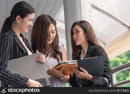 Businesswomen discussing monthly report meeting conference. Group of business people sharing planning working experience at outside office. Secretary having conversation gossip about boss or coworkers