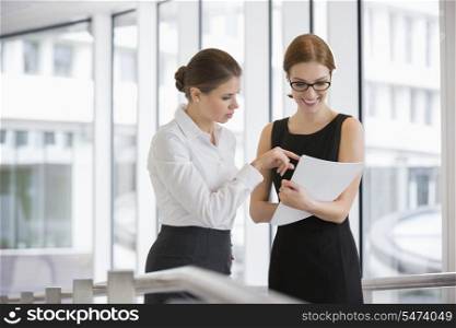 Businesswomen discussing over documents in office