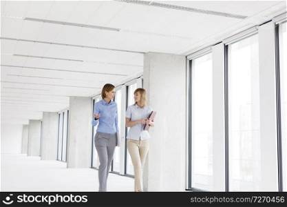 Businesswomen discussing while walking in empty new office