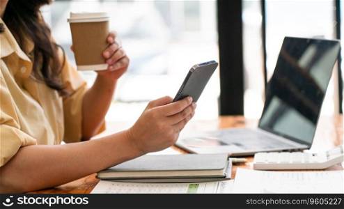 Businesswomen drink coffee and read data on smartphone while working business project at workplace. 