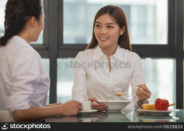 Businesswomen eating breakfast
