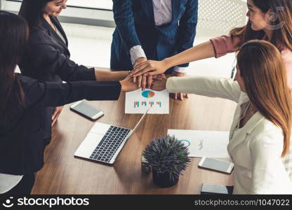 Businesswomen joining hands in group meeting at modern office room showing teamwork, support and unity in work and business. Female power and femininity concept.