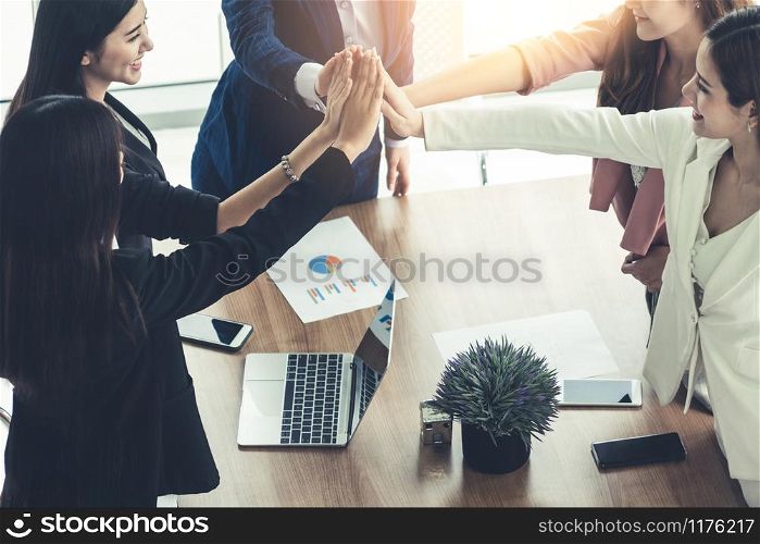 Businesswomen joining hands in group meeting at modern office room showing teamwork, support and unity in work and business. Female power and femininity concept.. Teamwork businesswomen joining hands in meeting.
