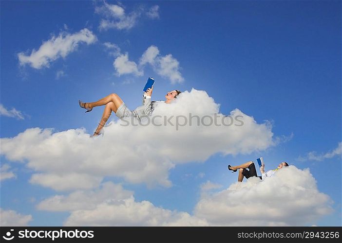 Businesswomen lying on clouds